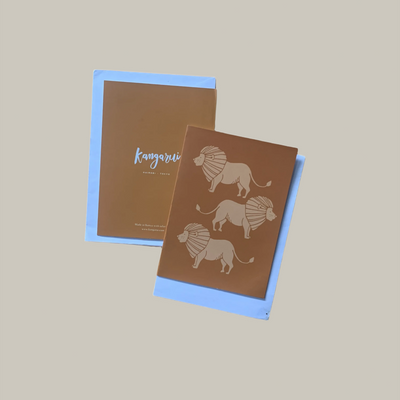 Two brown greeting cards with lion illustrations on a beige background