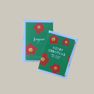 Two green Christmas cards with red flowers and text on a beige background
